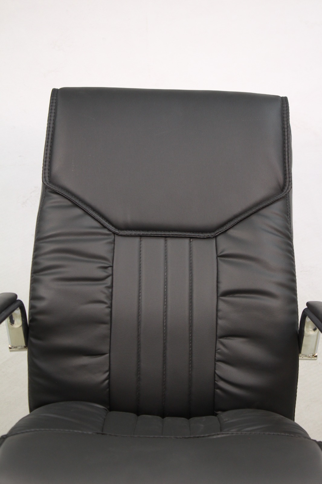Black Padded Executive Office Chair with Chrome Arms, close-up of the channel-stitched backrest